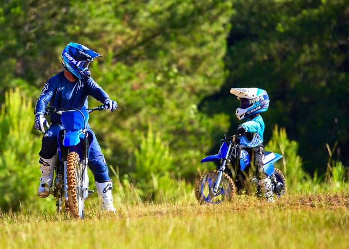 Adult Yamaha dirt bike rider and child on Yamaha pw50 kids motorbike